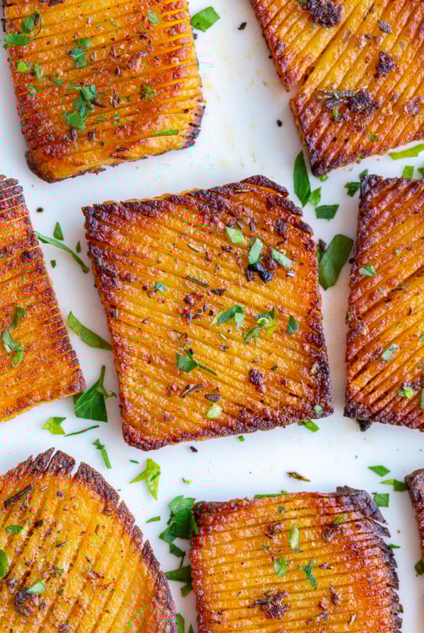 accordion potatoes on a plate sprinkled with parsley