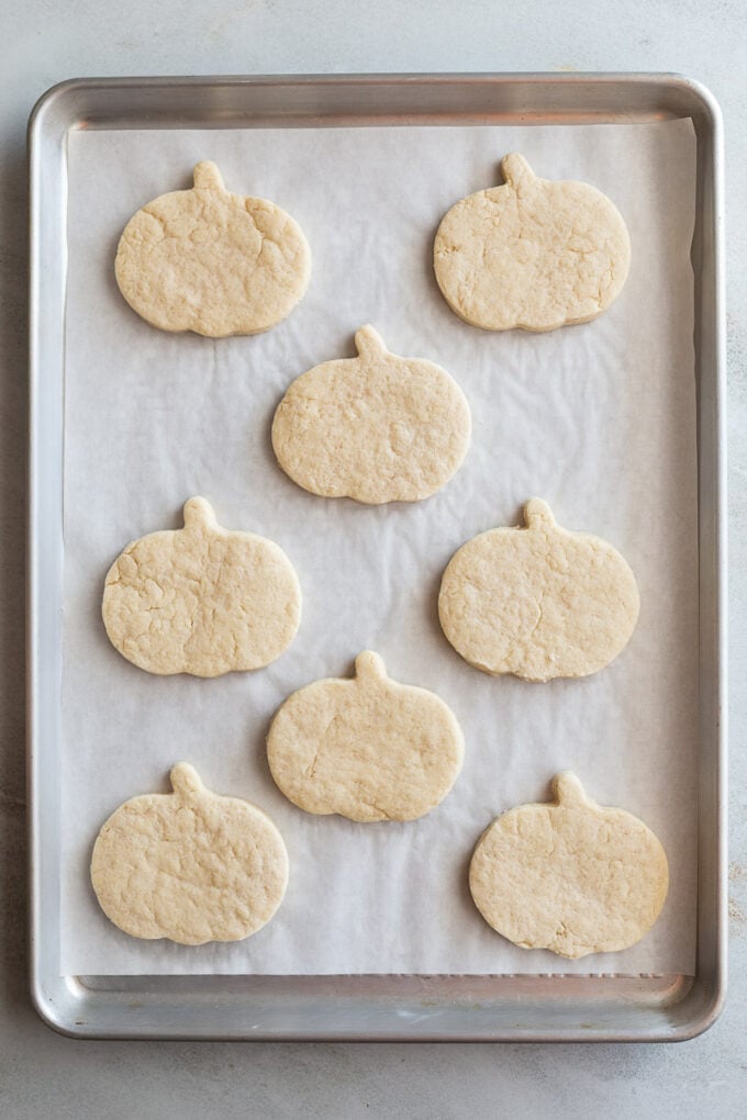 pumpkin shaped sugar cookies on a baking sheet