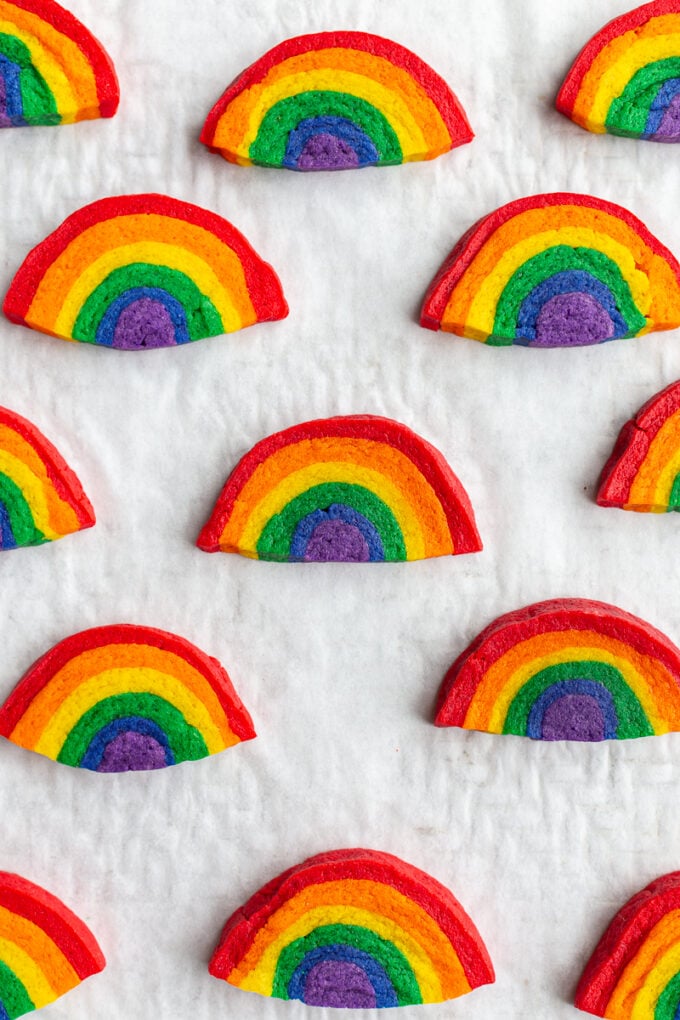 sugar cookies that look like rainbows all lined up on a baking sheet