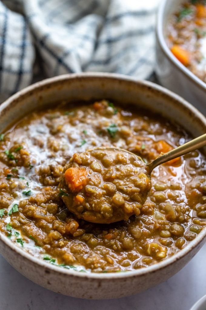 up close shot of a bowl of brown lentil soup with carrots in it